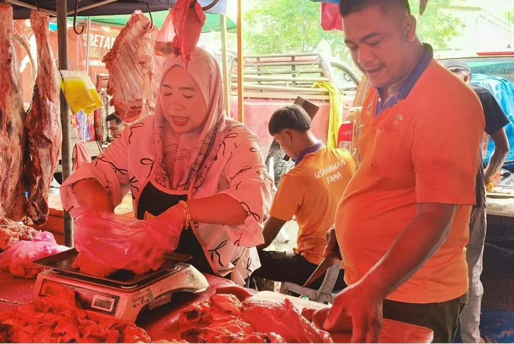 Mohd Khairul Anuar sibuk melayan pelanggan di gerai menjual daging miliknya di Pasar Tani UTC di sini.