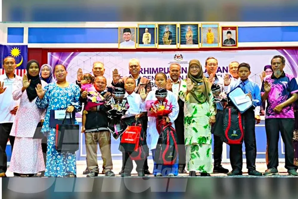 Siti Norina (tiga dari kanan) bersama pelajar Orang Asli dan ahli keluarga mereka pada Majlis Penyerahan Surat Tawaran SBP di Dewan Seri Tunjong, JPN Kelantan, Kota Bharu pada Ahad.