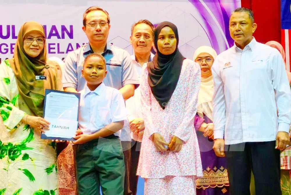 Siti Norina (kiri) pada Majlis Penyerahan Surat Tawaran SBP Kepada Murid Orang Asli di Dewan Seri Tunjong, JPN Kelantan, Kota Bharu pada Ahad.Foto SINAR HARIAN/HAZELEN LIANA KAMARUDIN