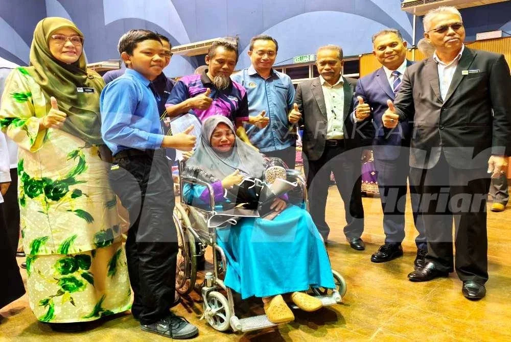 Nur Muhammad Al-Khawarizmi berkongsi kegembiraan bersama ibu bapanya pada Majlis Penyerahan Surat Tawaran SBP Kepada Murid Orang Asli di Dewan Seri Tunjong, JPN Kelantan, Kota Bharu pada Ahad.