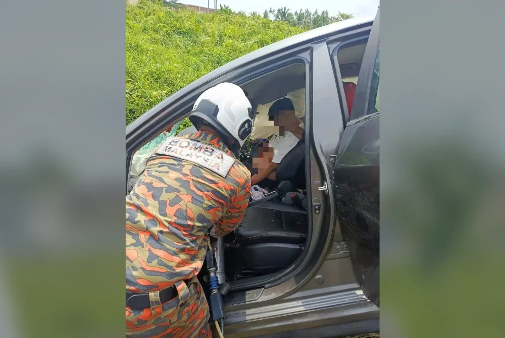 Anggota bomba dari Balai Bomba dan Penyelamat Hutan Melintang membantu mengeluarkan mangsa yang tersepit.