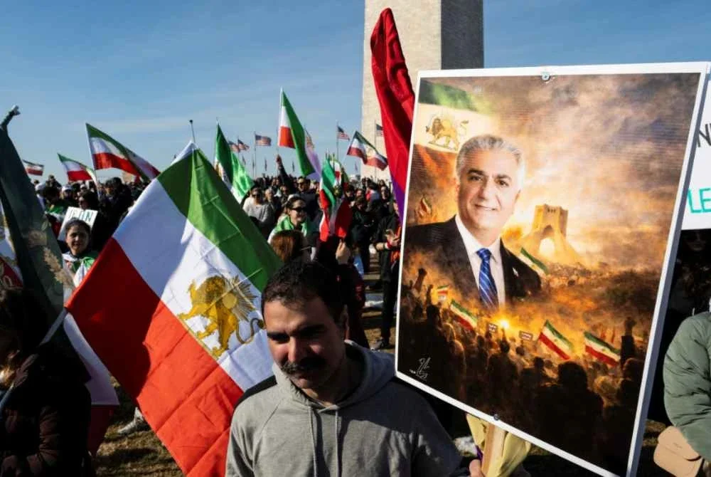 Demonstran membawa potret Shah Mohammad Reza Pahlavi yang digulingkan ketika kebangkitan revolusi di Iran pada 1979.
