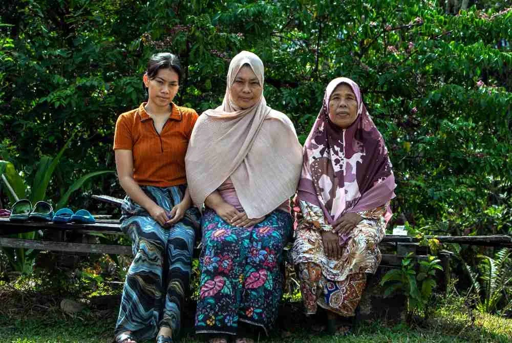 Norida Akmal (tengah) bergambar bersama anaknya Nur Fatin Akmadiana, 20, (kiri) dan ibu saudaranya Umi Kalsum Ahmad, 67, (kanan) ketika ditemui di Kampung Bukit Sapi, pada Isnin. Foto Bernama