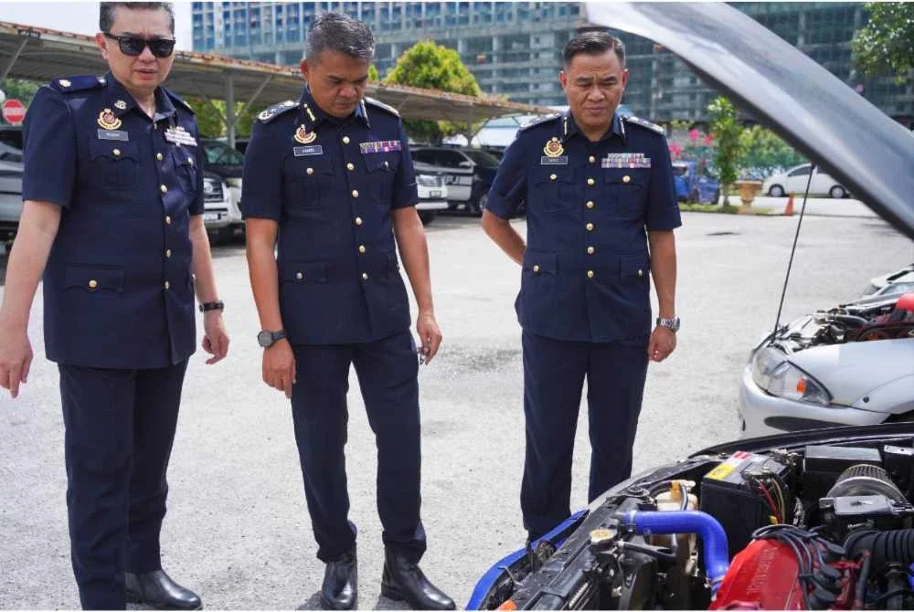 Hamidi (tengah) melihat kenderaan yang disita.