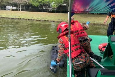 Anggota bomba membantu mengeluarkan mayat lelaki ditemukan lemas di Tasik Putrajaya di sini pada Isnin.