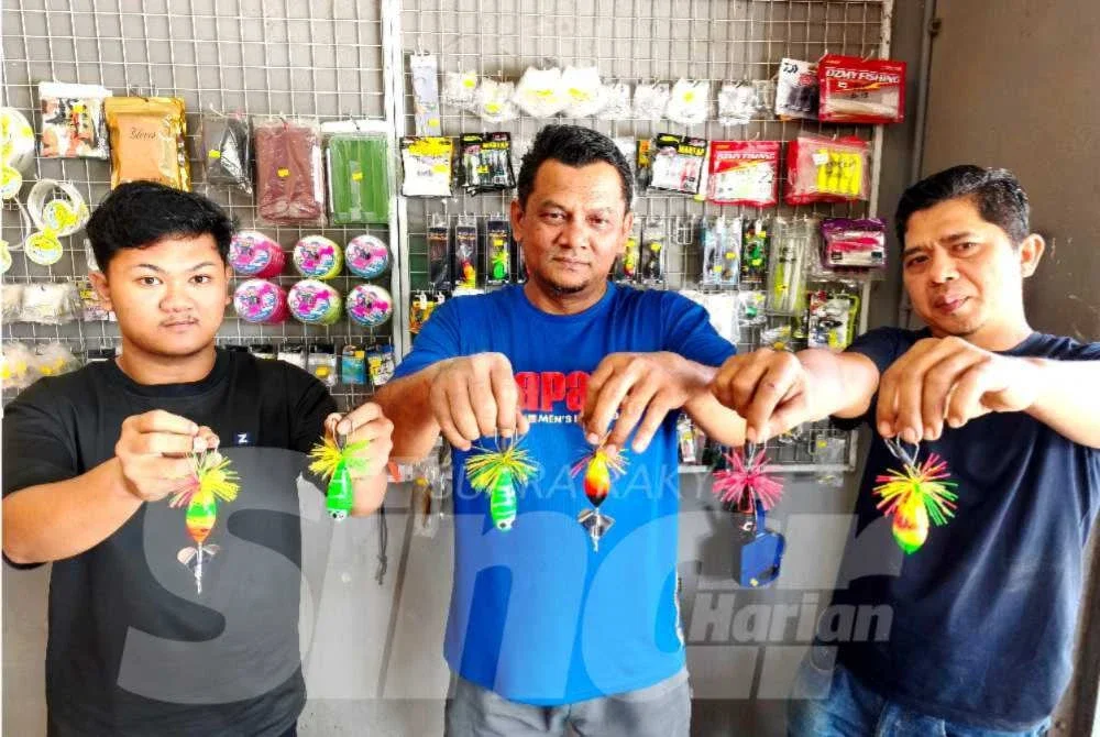 Pak Tam (tengah) bersama dua pembantunya menunjukkan jenis umpan yang dihasilkan mereka di kedainya di Bukit Marak, Kota Bharu. - Foto:SINAR HARIAN/HAZELEN LIANA KAMARUDIN