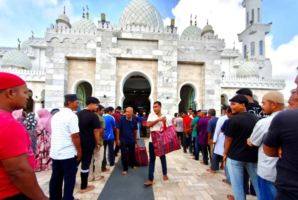 Penerima beratur mengambil bakul makanan yang disumbangkan Andalusia Travel & Tours Sdn Bhd.