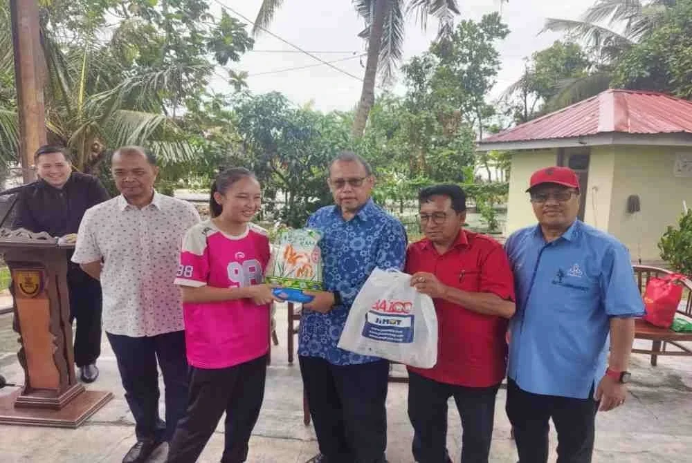 Abdul Fattah (tiga dari kanan) menyampaikan sumbangan kepada salah seorang penerima di Galeri Tanjong Karang Utara, Jalan Sungai Kajang Tanjong Karang, pada Selasa.