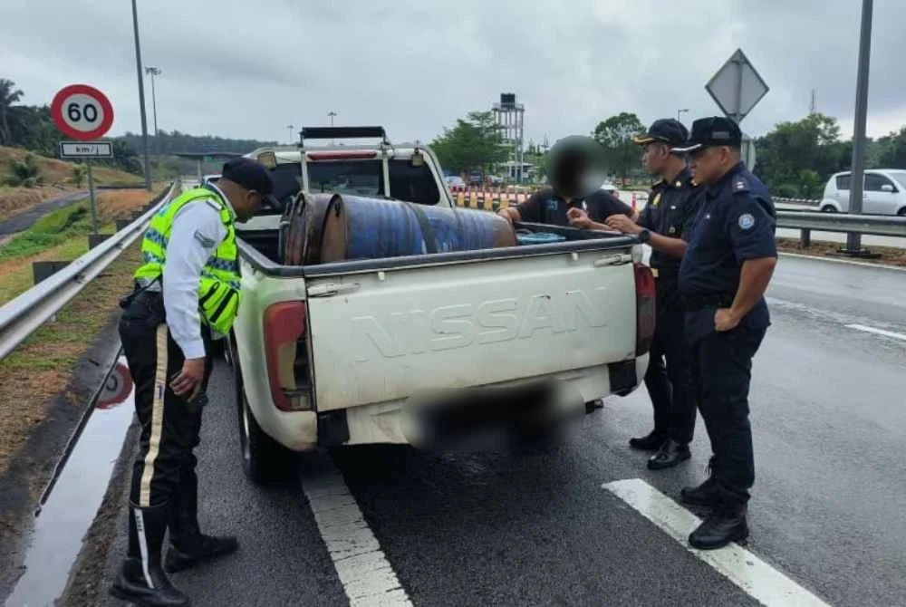 Pegawai penguat kuasa KPDN Pahang bersama anggota pasukan polis peronda lebuh raya memeriksa tong drum berisi diesel disyaki tanpa permit di atas kenderaan yang ditahan di Plaza Tol Kuantan pada Isnin. - Foto: KPDN Pahang