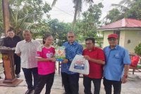 Abdul Fattah (tiga dari kanan) menyampaikan sumbangan kepada salah seorang penerima di Galeri Tanjong Karang Utara, Jalan Sungai Kajang Tanjong Karang, pada Selasa.