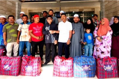 Dr Abdul Fattah (depan, lima dari kiri) menyampaikan bakul makanan kepada penerima pada Majlis Agihan Zakat Asnaf di Masjid Imanul Faizin, Kota Bharu pada Isnin.