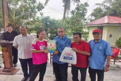 Abdul Fattah (tiga dari kanan) menyampaikan sumbangan kepada salah seorang penerima di Galeri Tanjong Karang Utara, Jalan Sungai Kajang Tanjong Karang, pada Selasa.