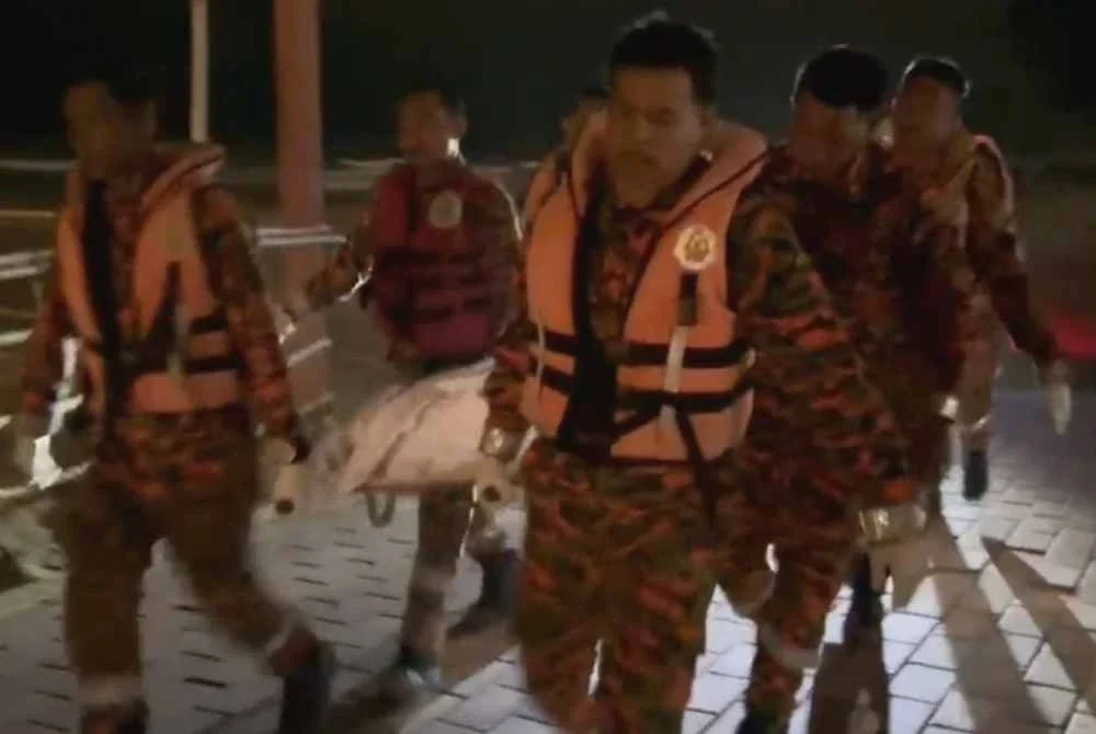 Anggota bomba membawa mayat pelajar warga Myanmar yang ditemui lemas di Pantai Batu Buruk