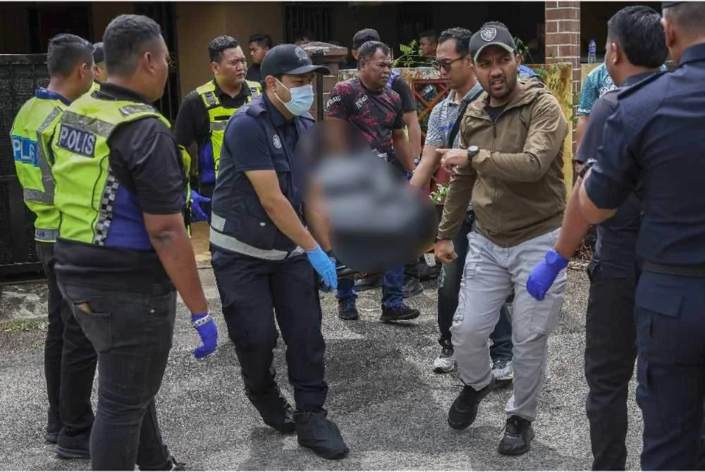 Polis membawa keluar lima mayat mangsa dalam kejadian bunuh di sebuah rumah di Lorong Cherating Damai di sini semalam. - Foto: Bernama