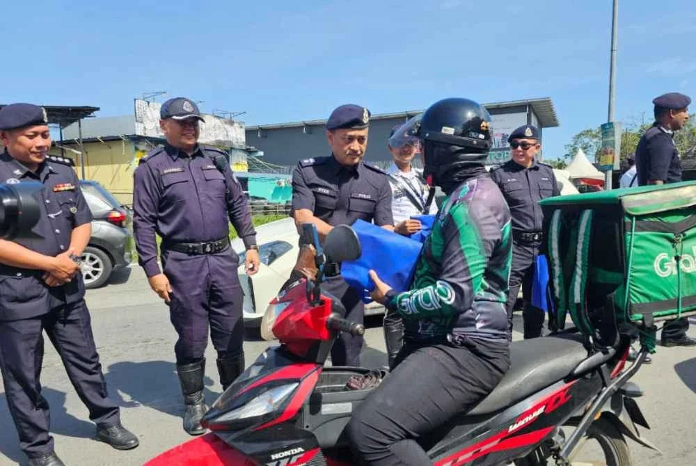 Syed Lot menyampaikan risalah keselamatan kepada pengguna jalan raya semasa melancarkan Ops Selamat Tahun Baharu Cina peringkat IPD Kota Kinabalu di Jalan Lintas, Kota Kinabalu.