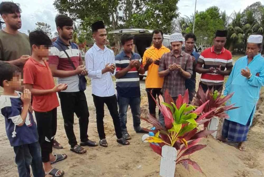 Zurahaque (tiga dari kanan) bersama komuniti Rohingya membacakan doa di pusara wanita hamil yang maut dibunuh suaminya menggunakan lesung di Tanah Perkuburan Islam Makam Dagang, Kampung Makam pada Rabu.