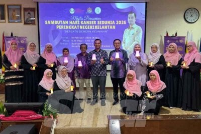 Dr Azman (tengah) bersama para doktor dan pesakit kanser memegang lampu sebagai gimik perasmian. 