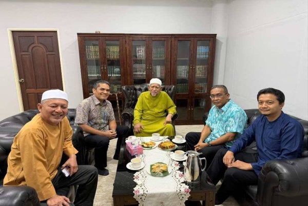 Mohd Radzi (dua dari kiri) memuat naik status memaparkan foto pertemuannya bersama Abdul Hadi (tengah). FOTO: Facebook Dr Mohd Radzi Jidin.