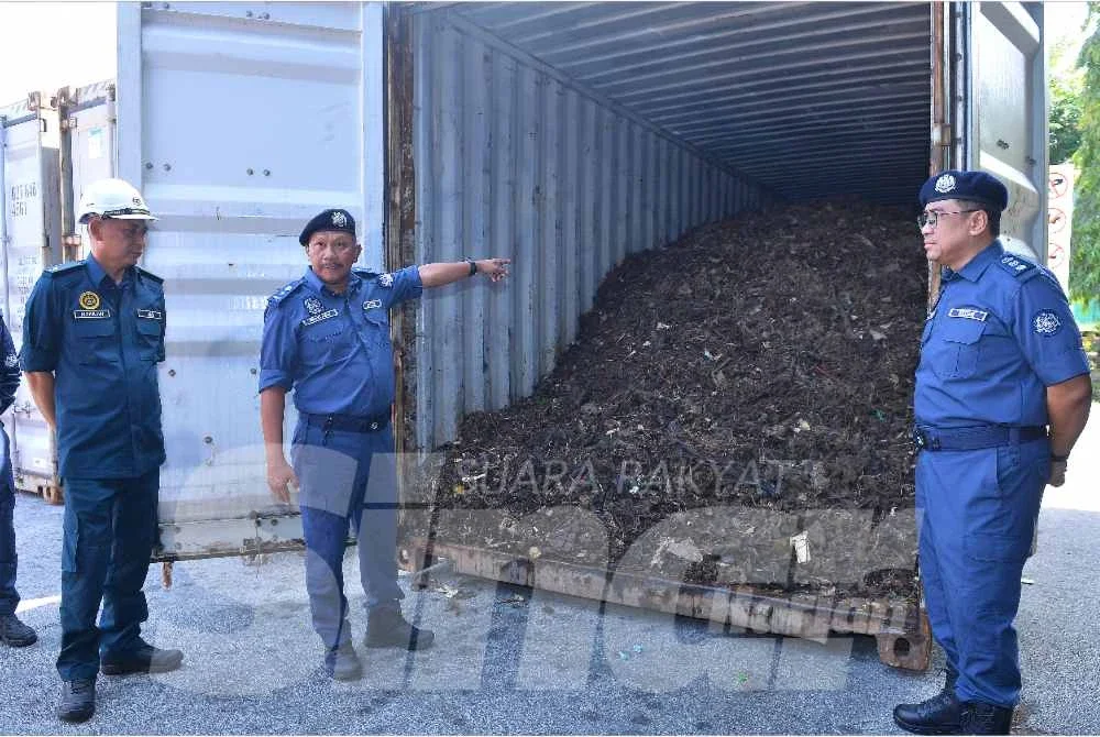 Mohd Asri (dua, kiri) menunjukkan antara kontena mengandungi bahan e waste yang dirampas.