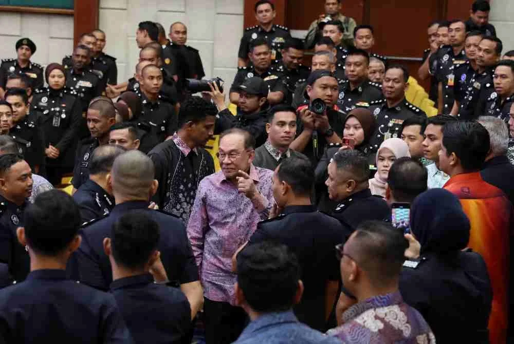 Anwar (tengah), beramah mesra bersama sebahagian warga kerja kementerian pada Majlis Perjumpaan Perdana Menteri bersama Warga Kerja Kementerian sempena Perhimpunan Bulanan Kementerian Dalam Negeri dan Ihya' Ramadan di Auditorium Setia Perkasa, pada Khamis. Foto Bernama