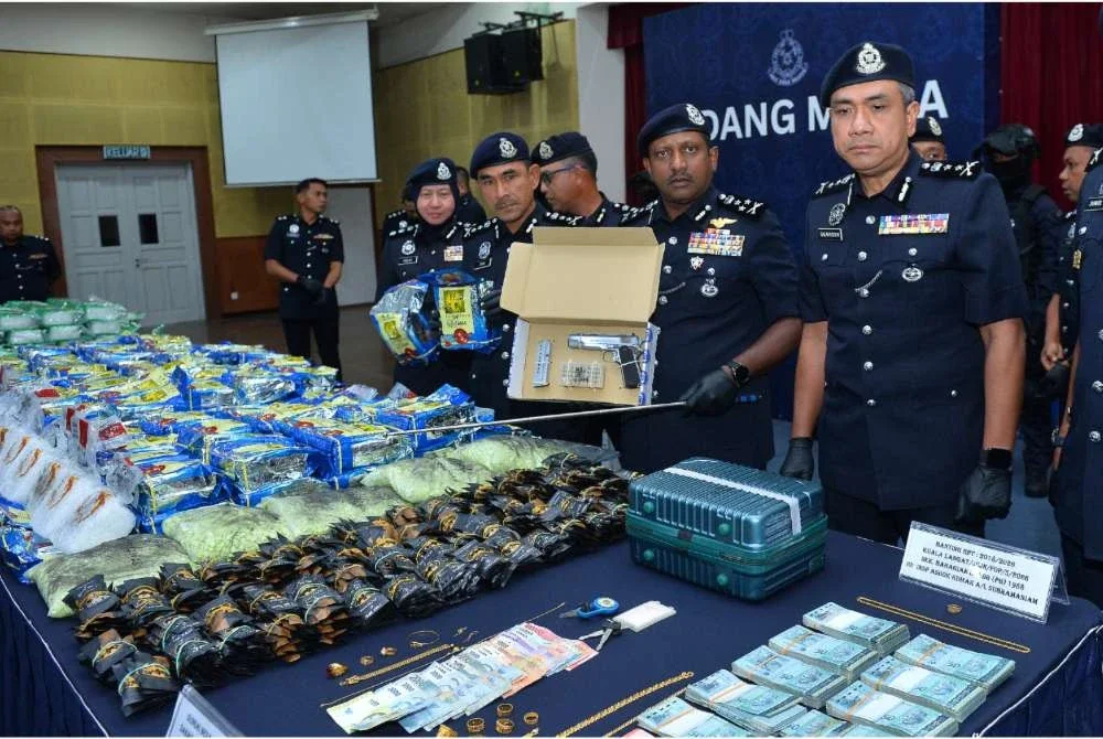 Hussein (dua dari kanan) menunjukkan pistol yang dirampas susulan tangkapan tiga individu melibatkan sindiket dadah di Sekinchan, Sabak Bernam. 