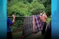 Wanita itu ditandu penduduk kampung bagi mencari bantuan. Foto Agensi