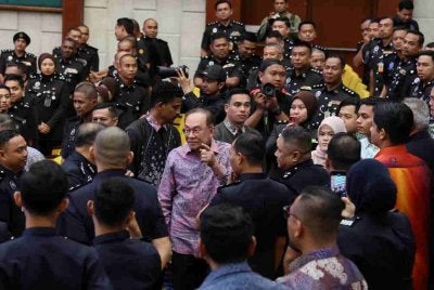 Anwar (tengah), beramah mesra bersama sebahagian warga kerja kementerian pada Majlis Perjumpaan Perdana Menteri bersama Warga Kerja Kementerian sempena Perhimpunan Bulanan Kementerian Dalam Negeri dan Ihya' Ramadan di Auditorium Setia Perkasa, pada Khamis. Foto Bernama 
