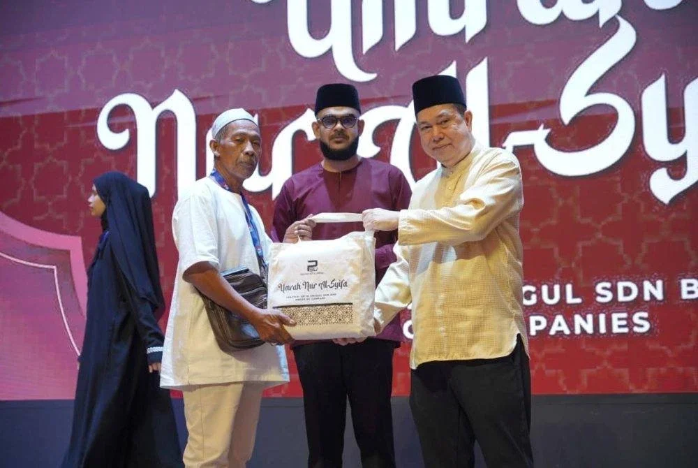 TENGKU Datuk Hishammuddin Zaizi (kanan) diiringi Mohammad Arrief (tengah) menyerahkan kelengkapan menunaikan umrah kepada asnaf baru-baru ini. 