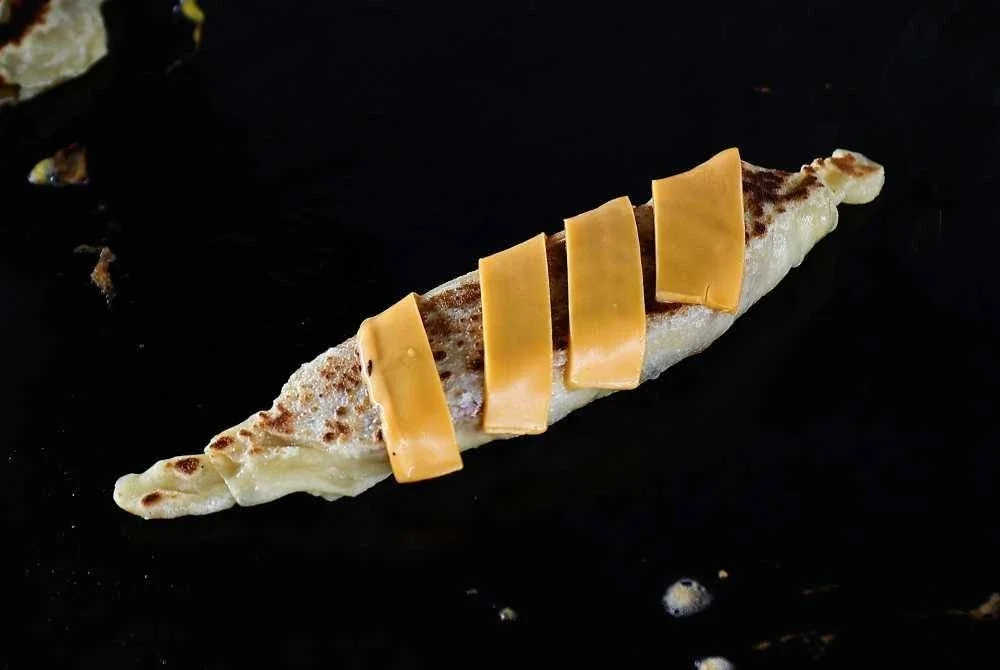 Kreativiti seorang peniaga di Bazar Ramadan Stadium Tuanku Abdul Rahman, Paroi mencuri perhatian apabila roti ‘pocong’ dan martabak jualannya kembali menjadi tarikan pengunjung tahun ini. Roti yang dibalut kemas menyerupai ‘pocong’ itu bukan sekadar unik pada rupa, Foto Bernama 