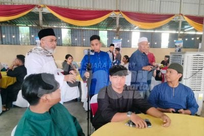 Syed Abu Hussin (berdiri kiri) menyantuni mahasiswa yang menghadiri Majlis Berbuka Puasa Bersama Mahasiswa Parlimen Bukit Gantang di Pusat Khidmat P069 Ahli Parlimen Bukit Gantang pada Jumaat.