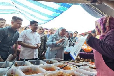 Fuziah (kanan) bertemu peniaga yang menawarkan hidangan pada harga serendah RM5 di Bazar Ramadan Rahmah Perling pada Jumaat.