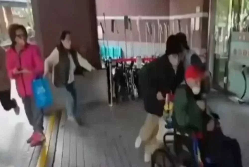 Rakaman CCTV menunjukkan anak Wang menolak kerusi roda ketika 'misi menyelamat' tersebut. - FOTO: Agensi