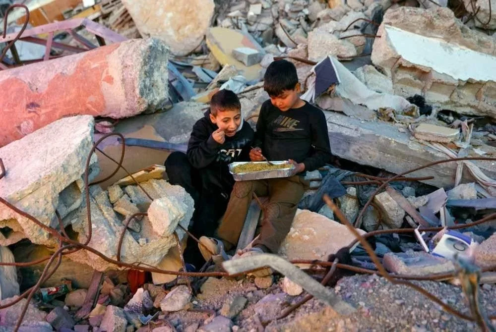 Dua kanak-kanak Palestin berkongsi juadah berbuka puasa.
