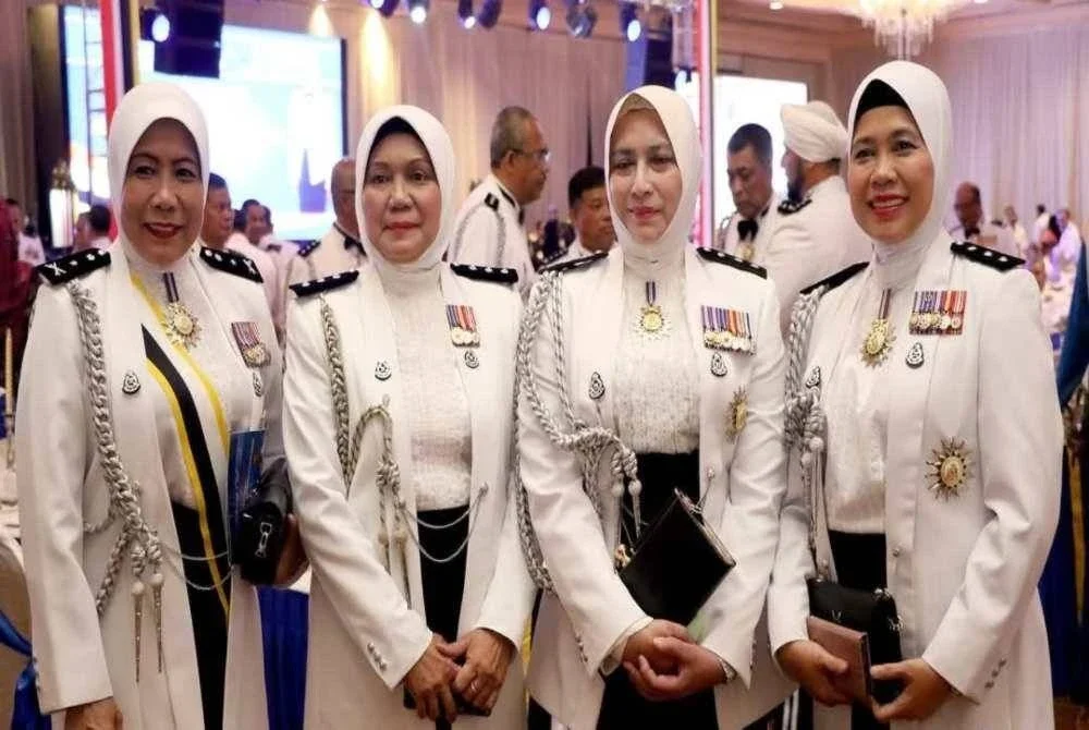 Asmawati (kiri) bersama rakan setugas dalam PDRM.