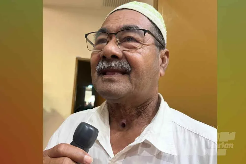 Ismail memegang alat pembesar suara untuk bercakap.