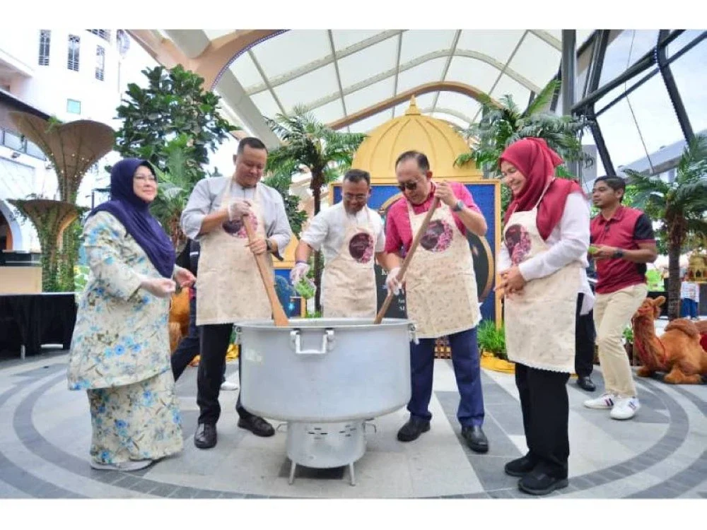 Amirudin (tengah) bersama-sama Mahmud (dua dari kanan) dan Rizam (dua dari kiri) mengacau bubur lambuk pada program Ramadan Kasih anjuran PKNS di sini, Jumaat.