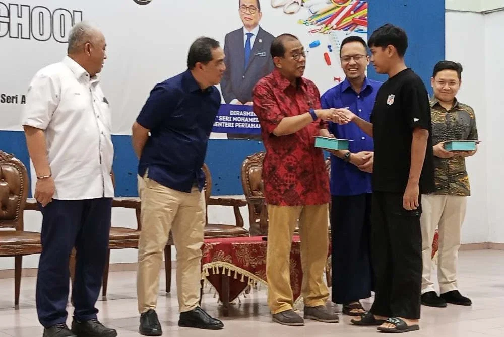 Mohamed Khaled (tiga dari kiri) menyerahkan sumbangan Back To School di Dewan Muafakat Bandar Seri Alam pada Sabtu.