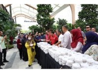 Amirudin (tiga, kanan) bersama pemain Selangor FC mengedarkan bubur lambuk PKNS kepada orang ramai di di Aneka Walk di sini pada Jumaat.