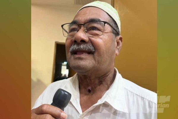 Ismail memegang alat pembesar suara untuk bercakap.