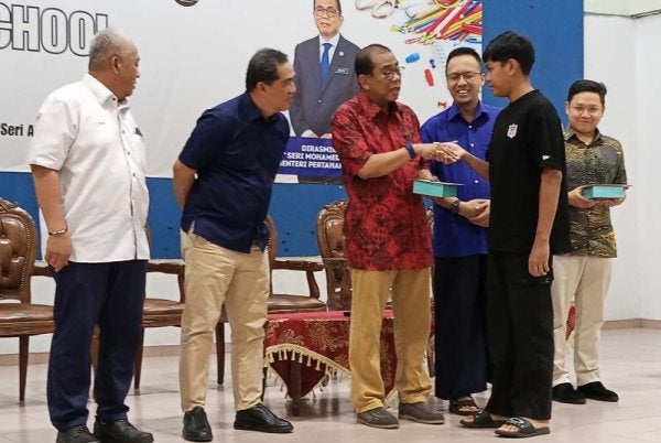 Mohamed Khaled (tiga dari kiri) menyerahkan sumbangan Back To School di Dewan Muafakat Bandar Seri Alam pada Sabtu.