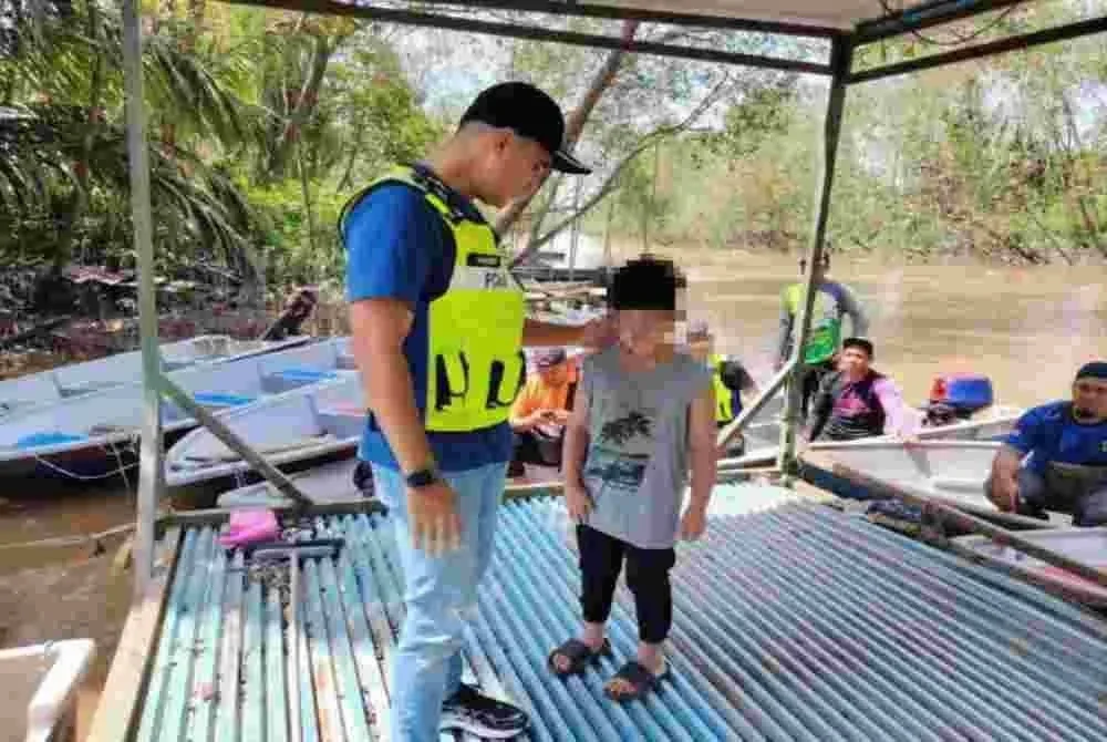 Hadzrat Hussien bersama kanak-kanak malang itu ketika operasi mencari dan menyelamat bapanya yang dikhuatiri lemas di Sungai Parit Bugis, Pontian.