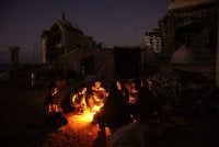 Keluarga al-Ghafir yang dipindahkan berbuka puasa di sisi khemah mereka yang didirikan di celah runtuhan Masjid al-Hasayna, Gaza City. - AFP