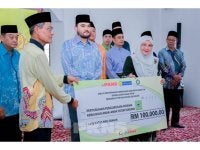 Sapna (kanan) menyerahkan simbolik cek kepada Ahmad Bustamam Abdul Latiff (kiri) sambil disaksikan Raja Muda Selangor, Tengku Amir Shah pada Majlis Penyerahan Sumbangan Hari Raya di Asrama Kebajikan Anak-Anak Yatim Miskin Sekendi di sini pada Sabtu.
