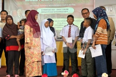 Siti Norina (dua dari kiri) yang mengiringi tiga pelajar Orang Asli mendaftar SBP di Kota Bharu. Foto: ADILA SHARINNI WAHID