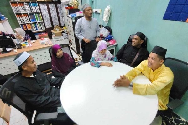 Pengerusi Persatuan Orang-Orang Cacat Penglihatan Islam Malaysia (PERTIS) Terengganu, Fauzi Mansor (berdiri) berbual bersama tiga pasangan OKU penglihatan ketika ditemui pemberita.
