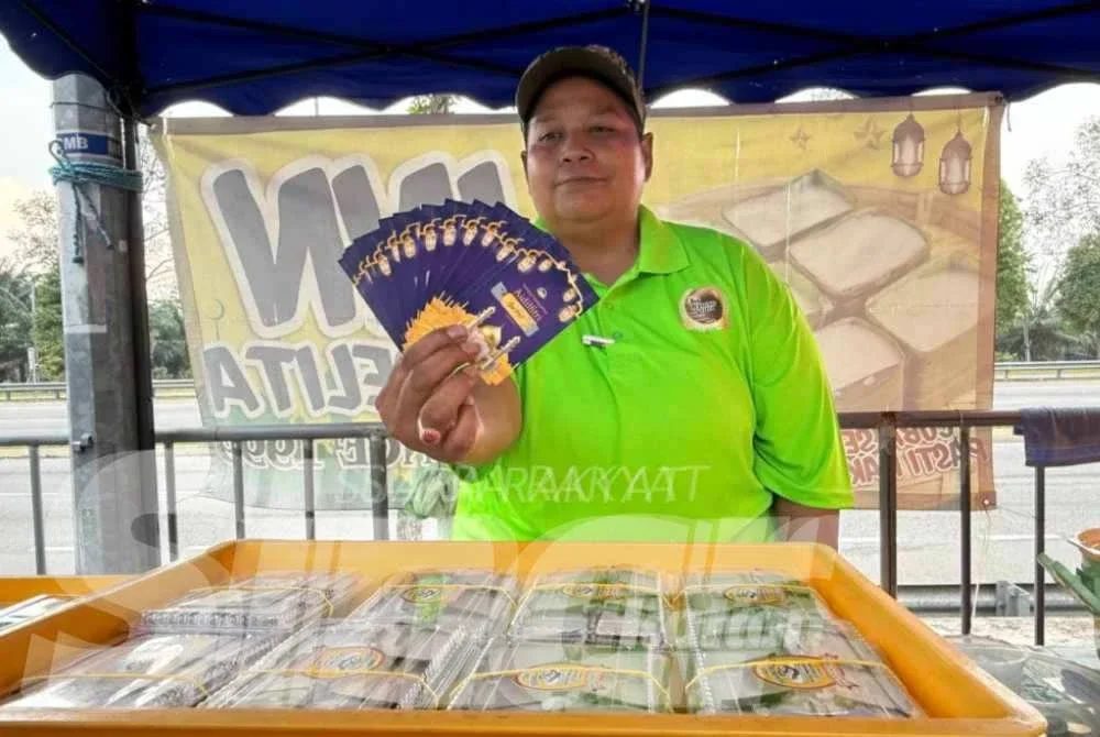 Azlina menunjukkan kad gores menang yang telah ditebus.