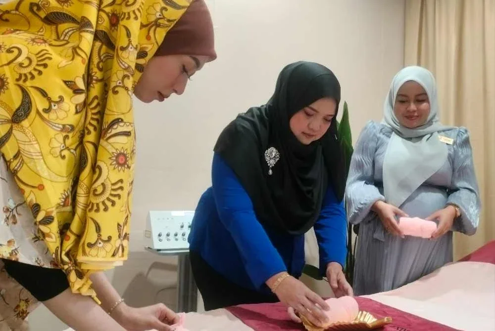 Nabiha (kanan) membuat persediaan menerima pengunjung ke spa yang diuruskannya.