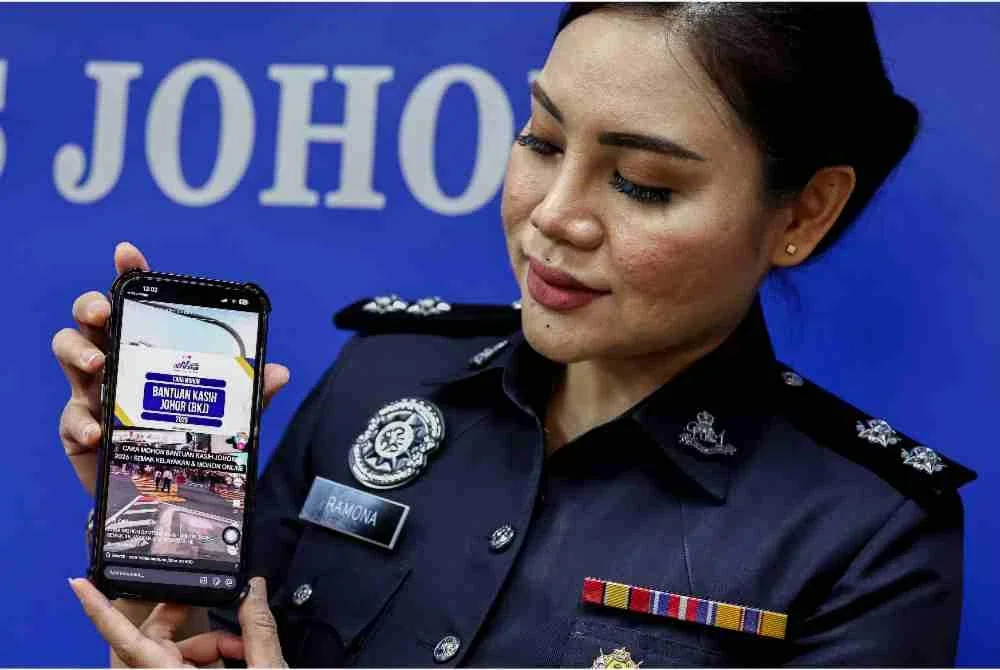 Media Ibu Pejabat Polis Kontinjen Johor, Inspektor Ramona Roslan, menunjukkan antara akaun penipuan promosi Bantuan Kasih Johor di TikTok pada sidang media berhubung sindiket scam AI yang meniru wajah dan suara Exco Johor bagi mempromosikan bantuan tersebut, di Ibu Pejabat Polis Kontinjen Johor, pada Selasa. Foto Bernama
