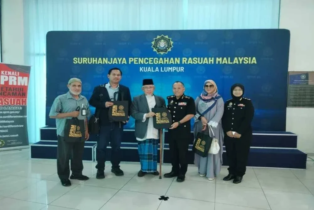 Mohamad Zakkuan (tiga kanan) menyampaikan cenderahati kepada Presiden Mapim, Mohd Azmi.