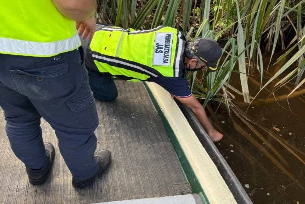 Kakitangan JAS KEdah sedang melakukan pemeriksaan di sepanjang sungai berdekatan lokasi kejadian. FOTO: JAS